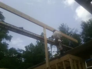 Carpenter setting a ridge beam over a new addition frame — Ice Dam Removal by Roofing Brothers in Valley Grove