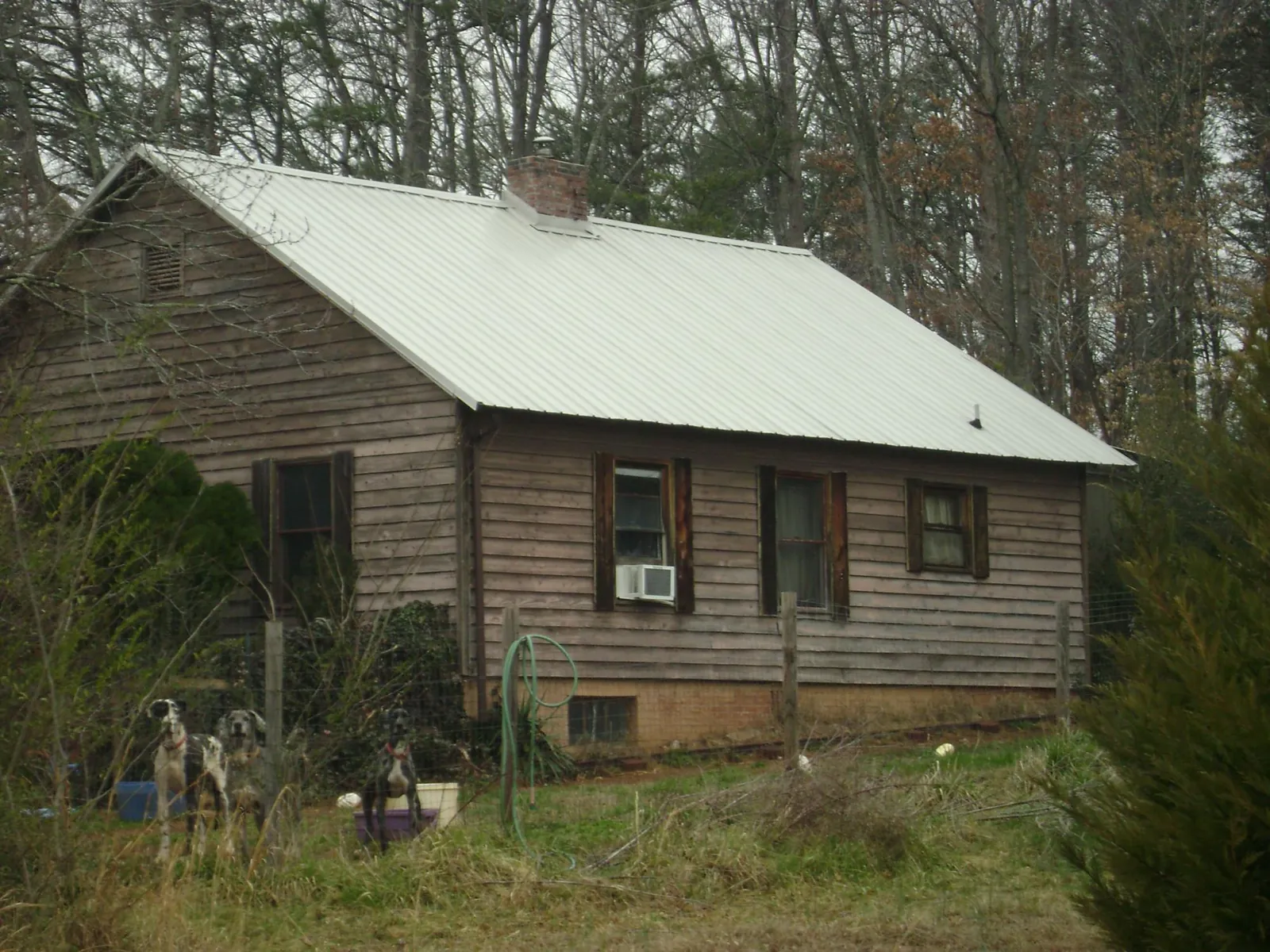 White metal roof on an old wood sided farmhouse, from a Metal Roof Installation job in Valley Grove